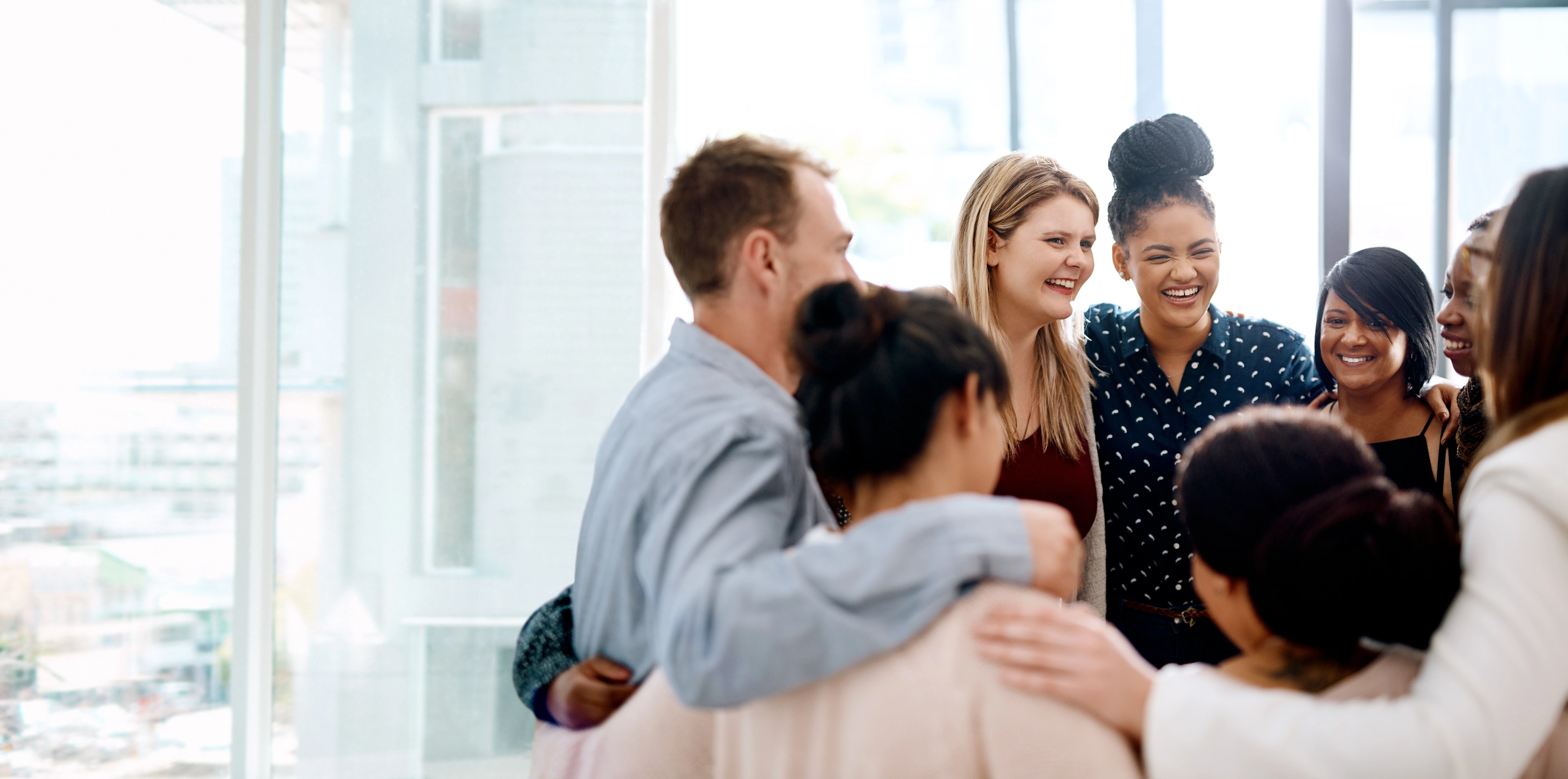 A group of young professionals standing together in a circle.